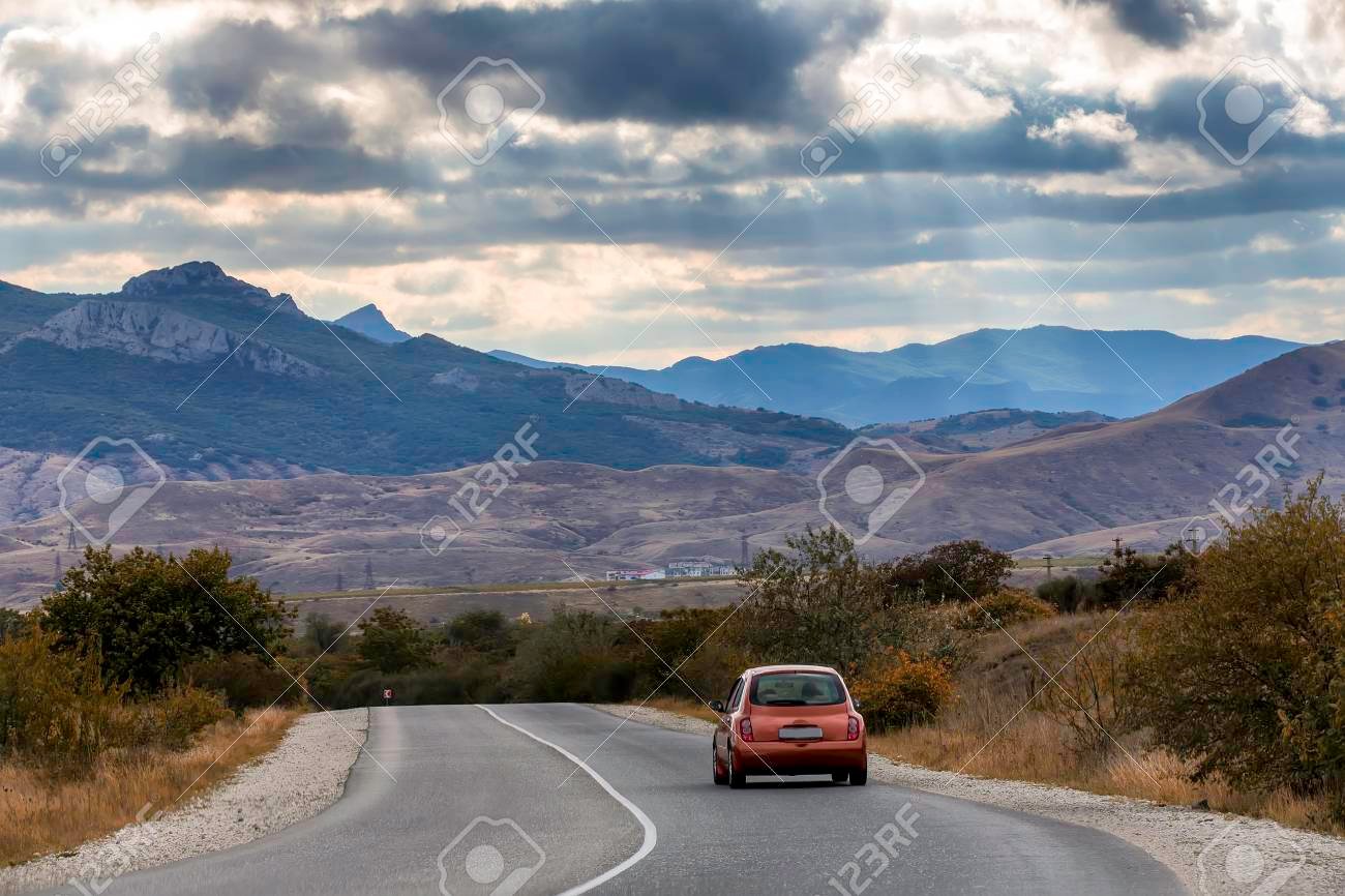 auto rojo en carretera con paisaje