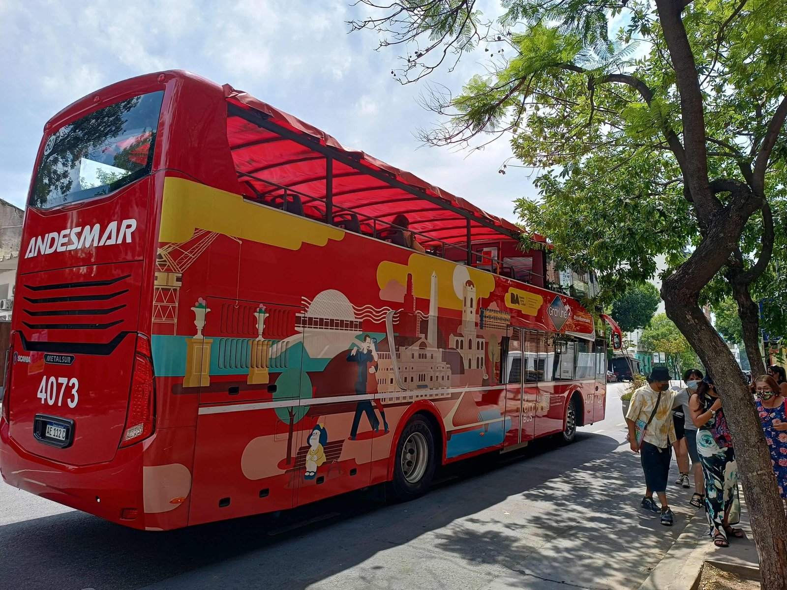 autobus turistico rojo recorriendo la ciudad scaled
