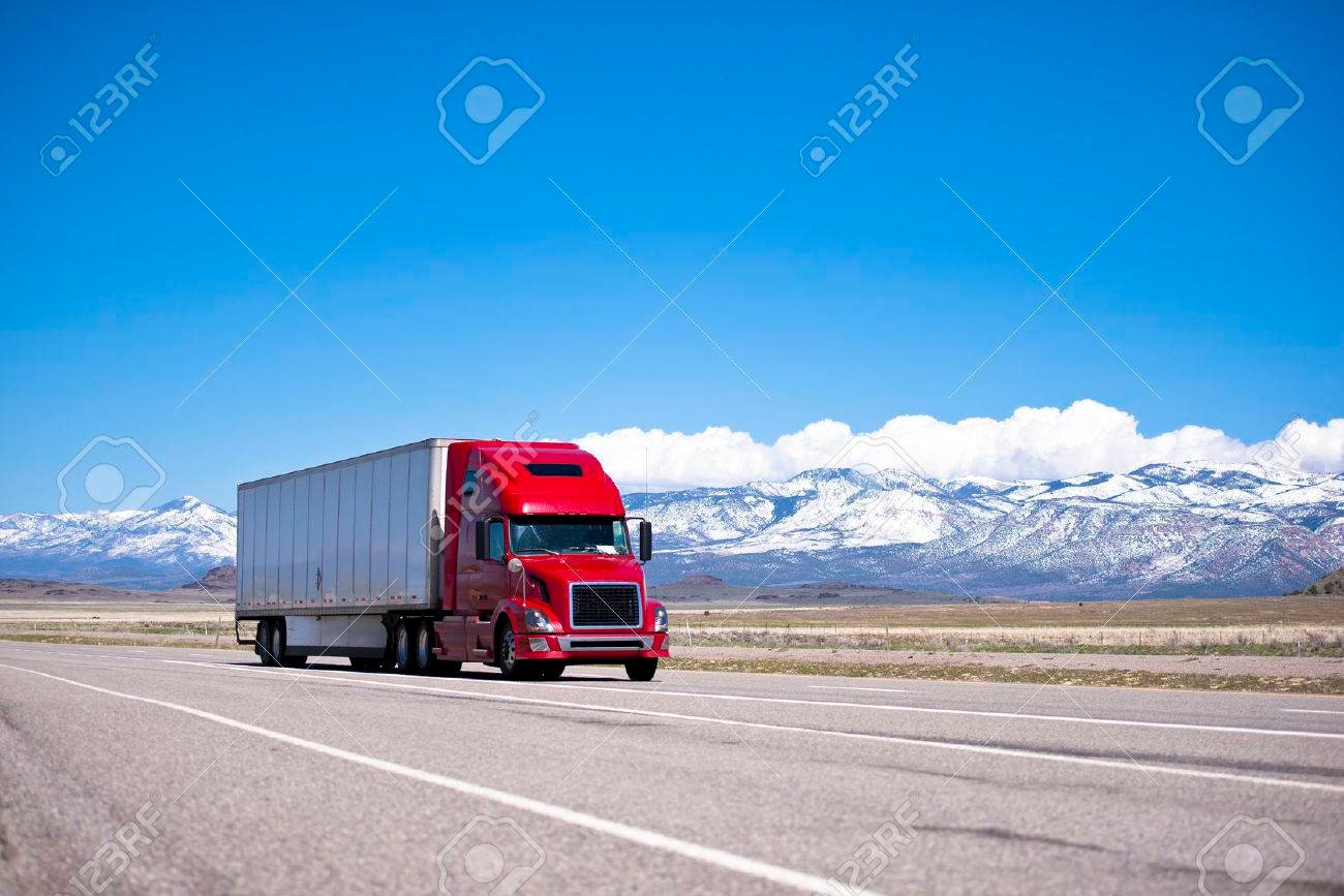 camion rojo en carretera de montanas nevadas