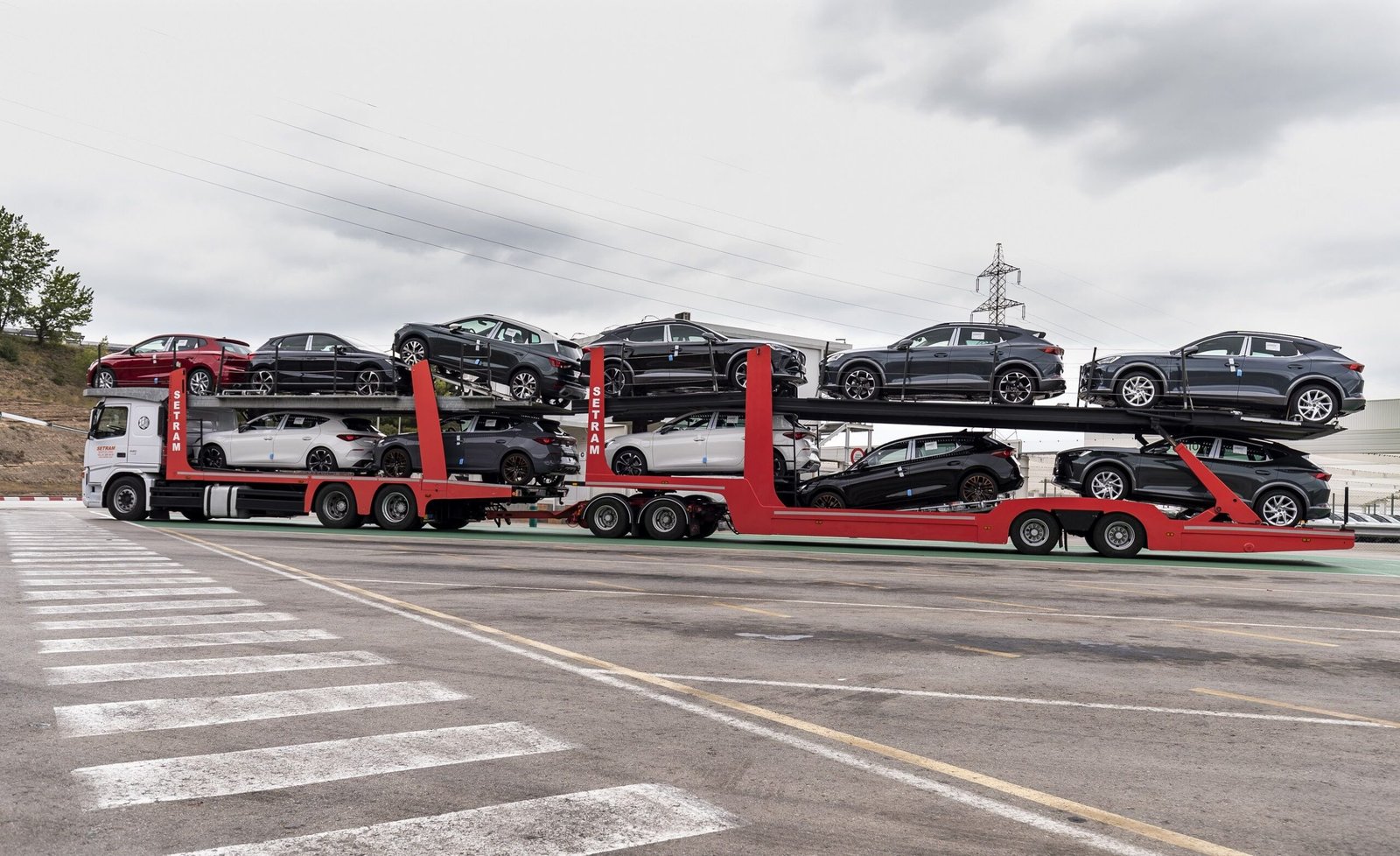 camion transportando autos en la carretera scaled