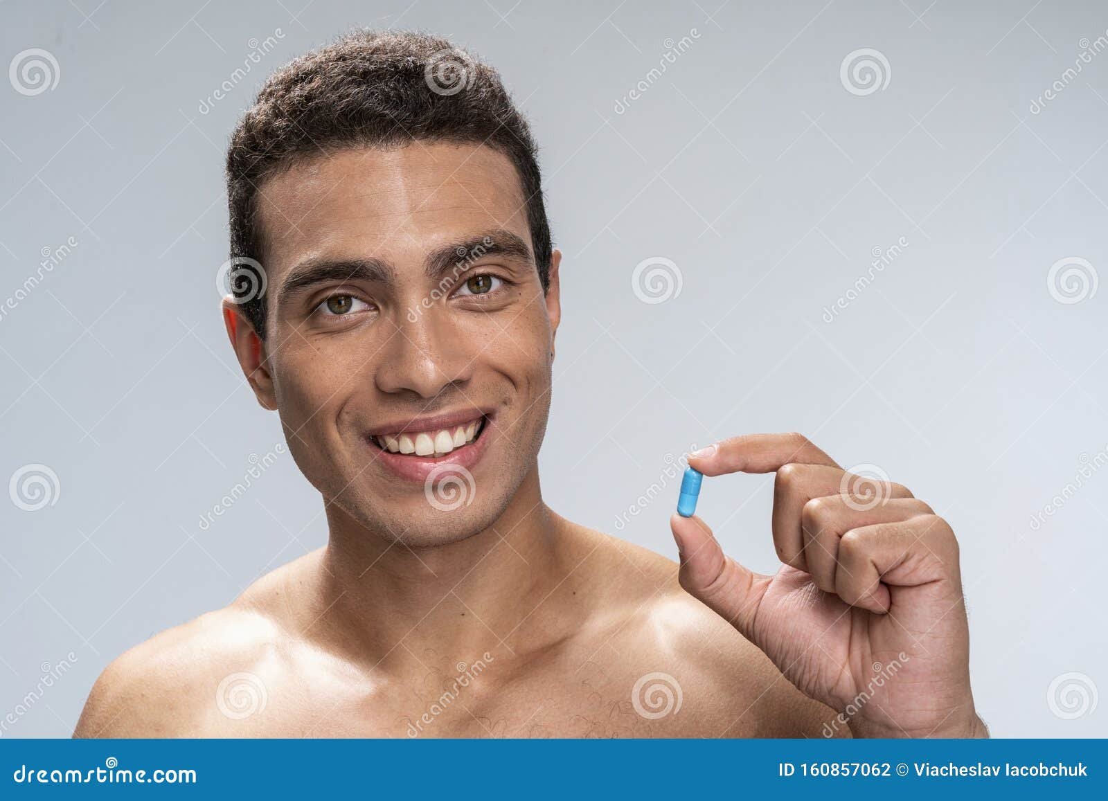hombre sonriente con comprimido azul en mano