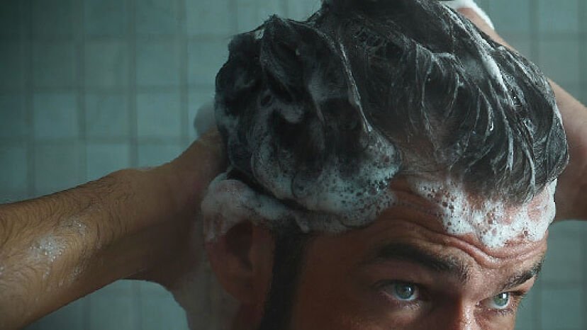hombre usando champu para cabello gris