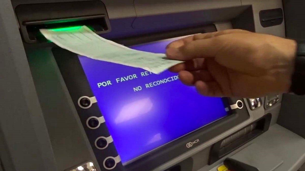 manos depositando cheque en cajero automatico
