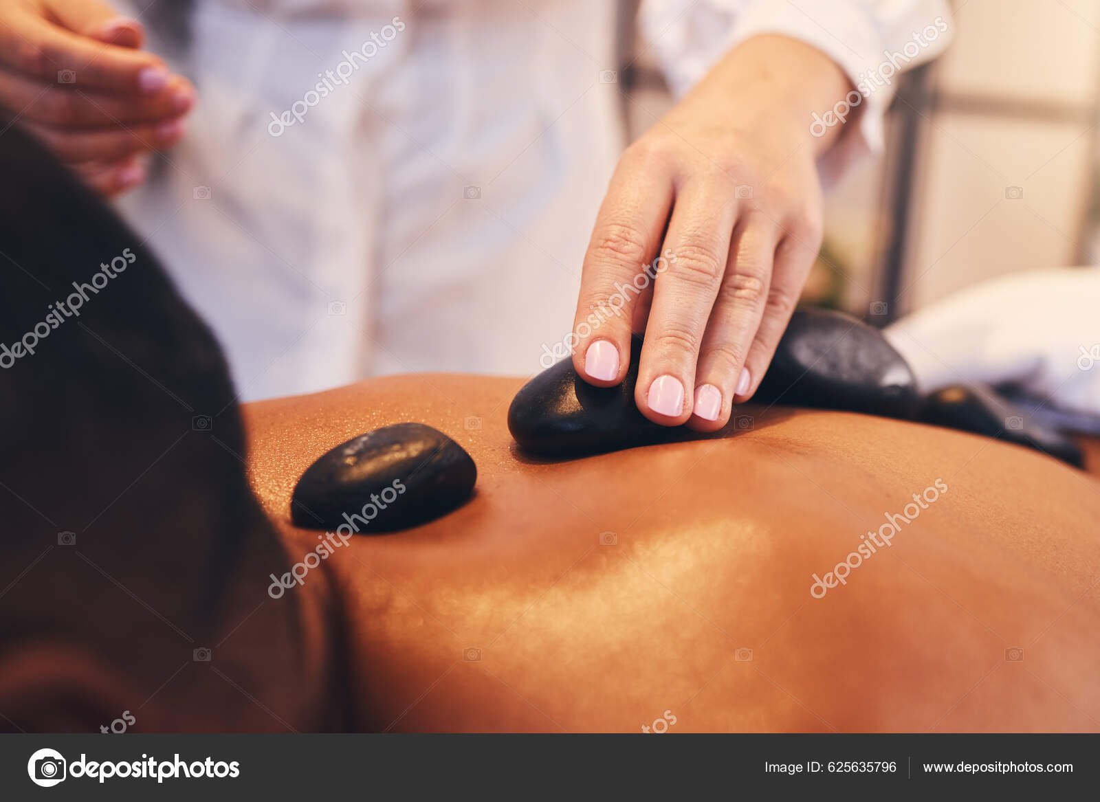 manos recibiendo un relajante masaje de piedras