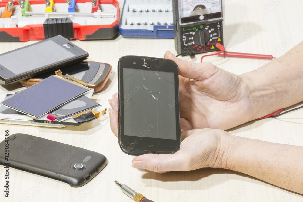 manos reparando pantalla de telefono movil