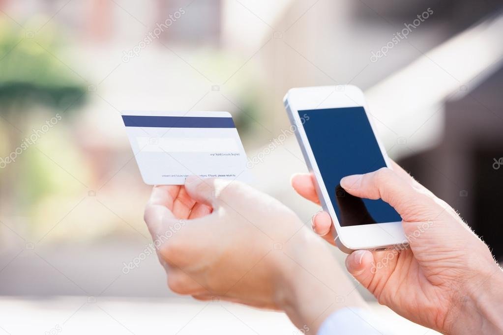 manos sosteniendo tarjeta de credito y telefono