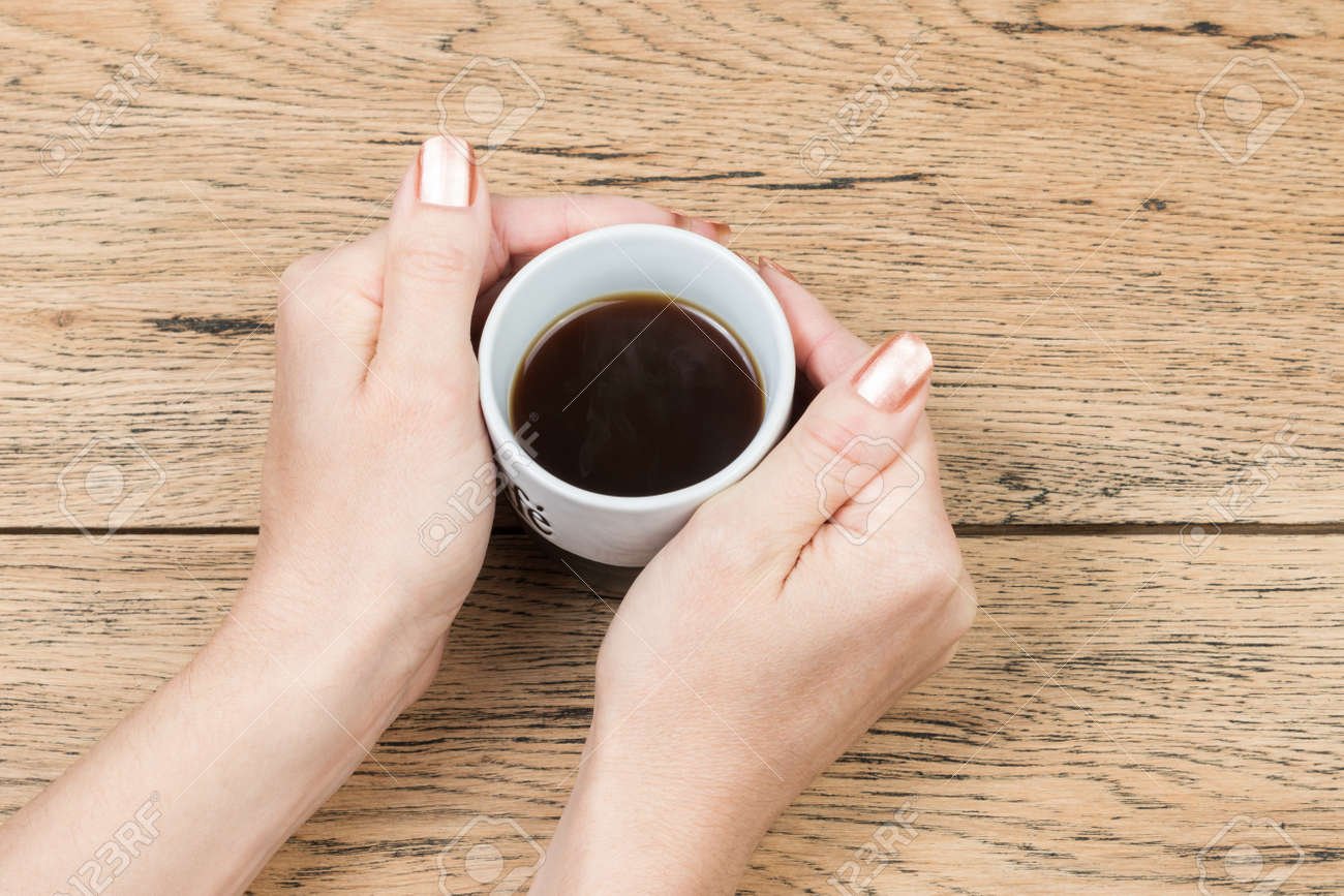 manos sosteniendo taza de cafe caliente