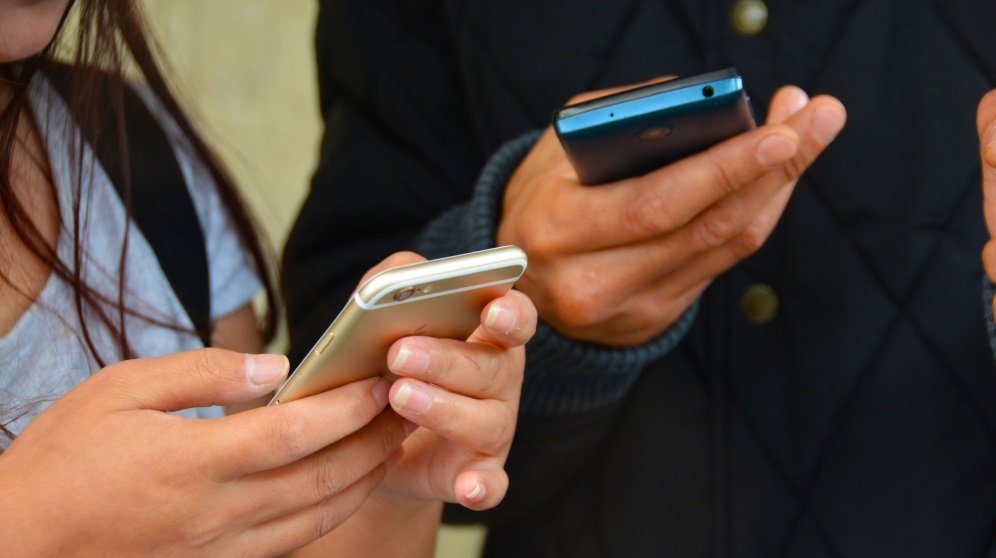 manos usando telefono para hacer transferencias bancarias