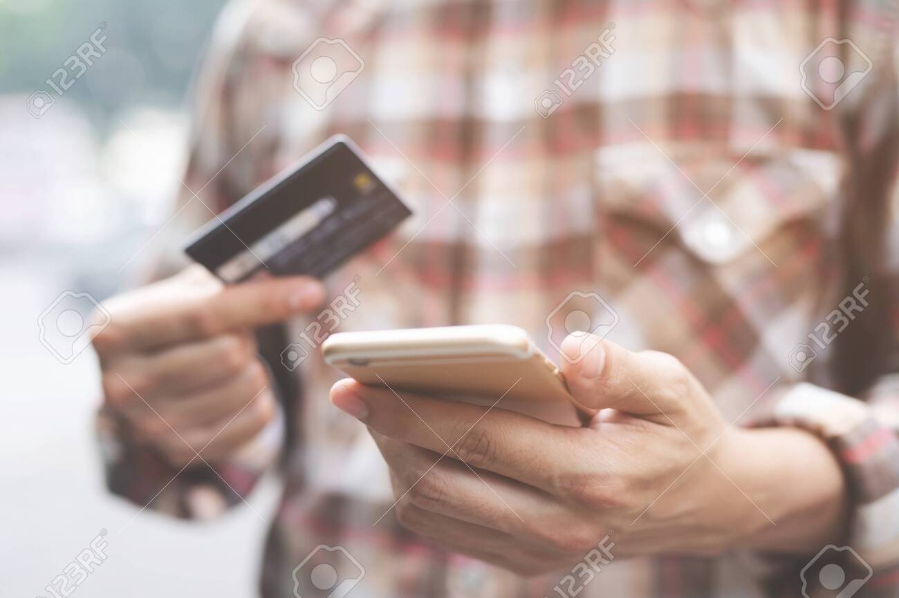 manos usando telefono para pagar tarjeta