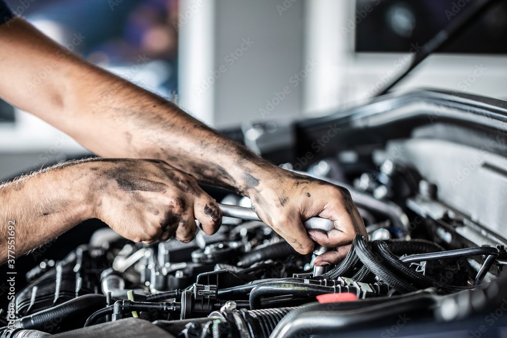 mechanic repairing a car engine in garage