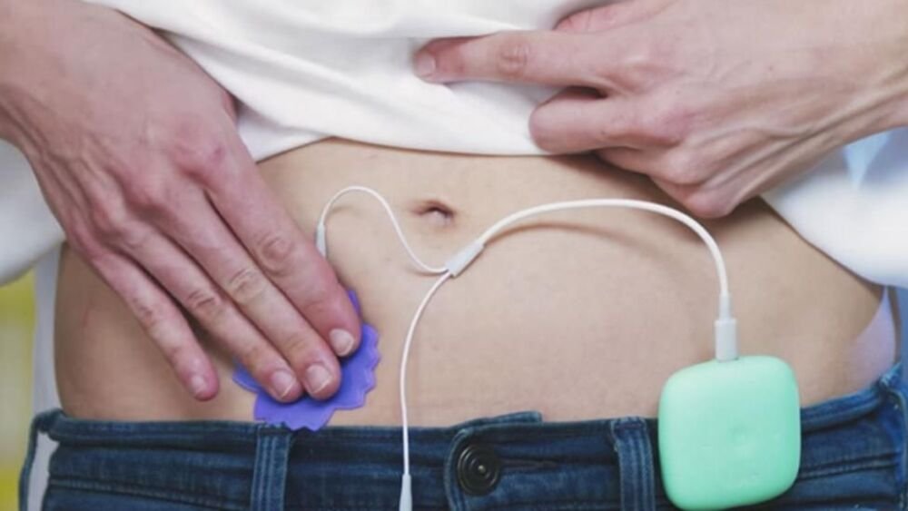 mujer aliviando dolor menstrual con dispositivo innovador