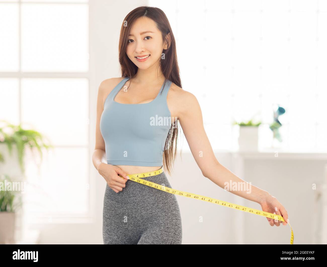 mujer feliz midiendo su cintura