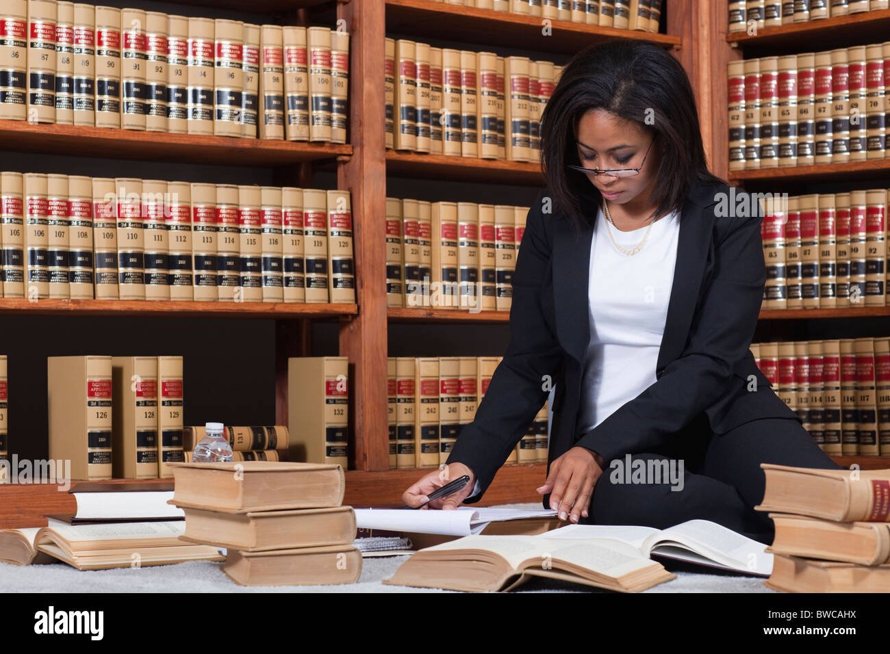 mujer leyendo libros en una biblioteca
