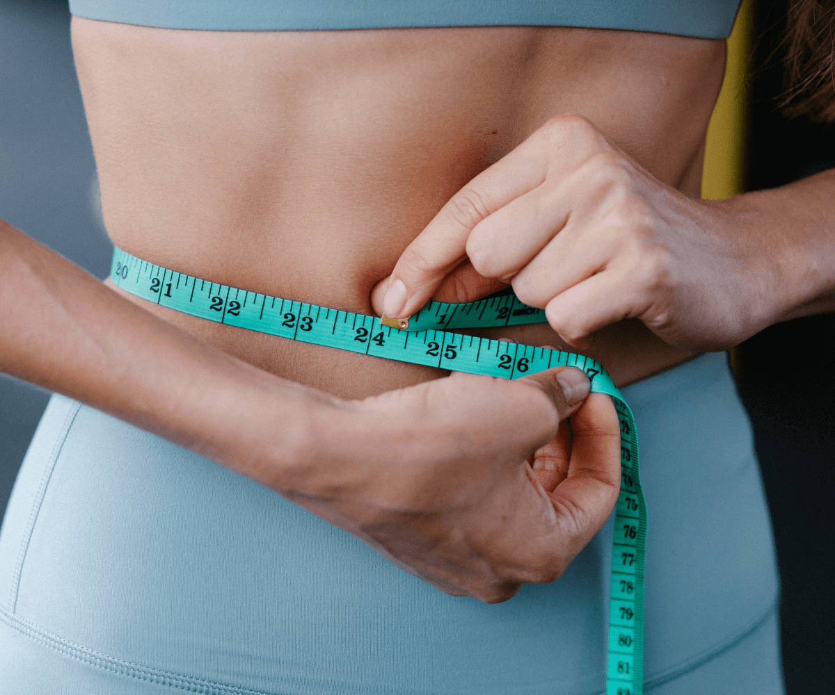 mujer midiendo su contorno con cinta metrica