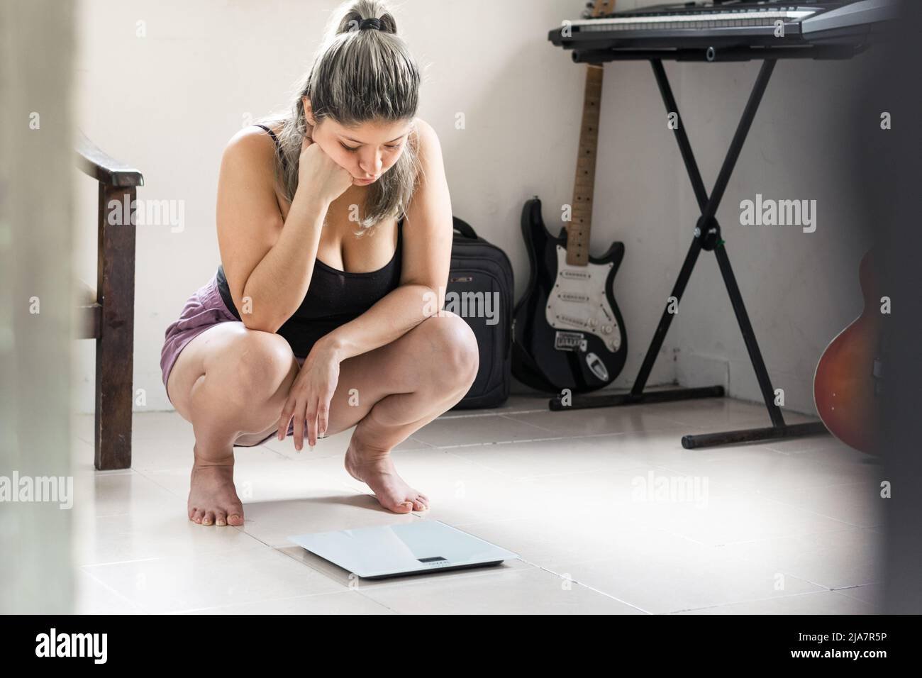 mujer preocupada mirando la bascula