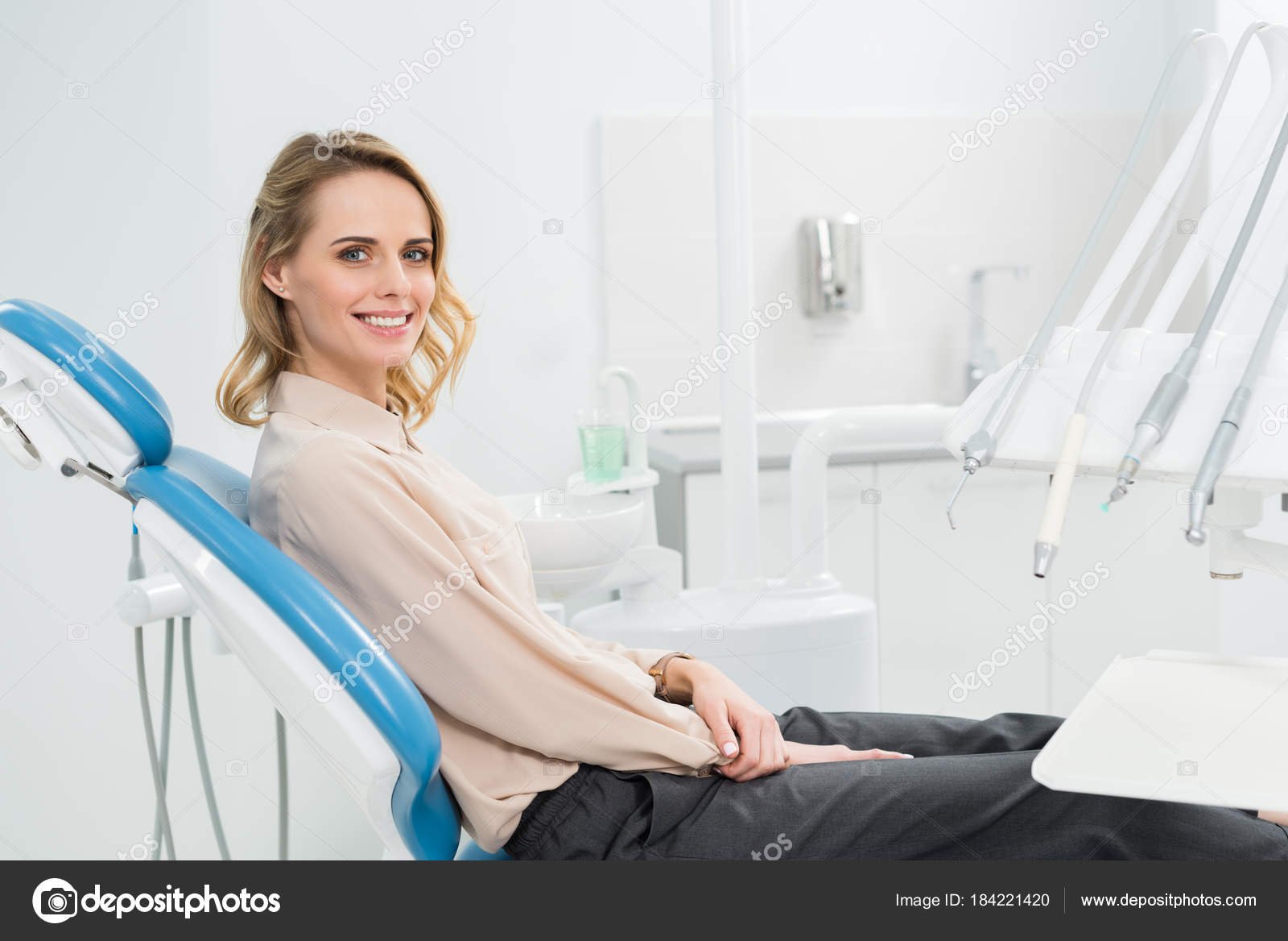 mujer sonriendo en consulta dental moderna