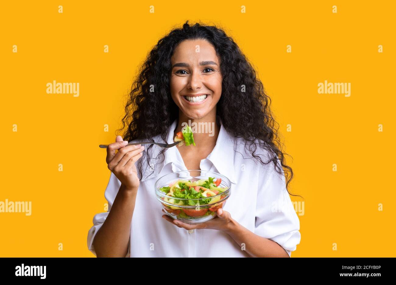 mujer sonriente disfrutando de alimentos saludables