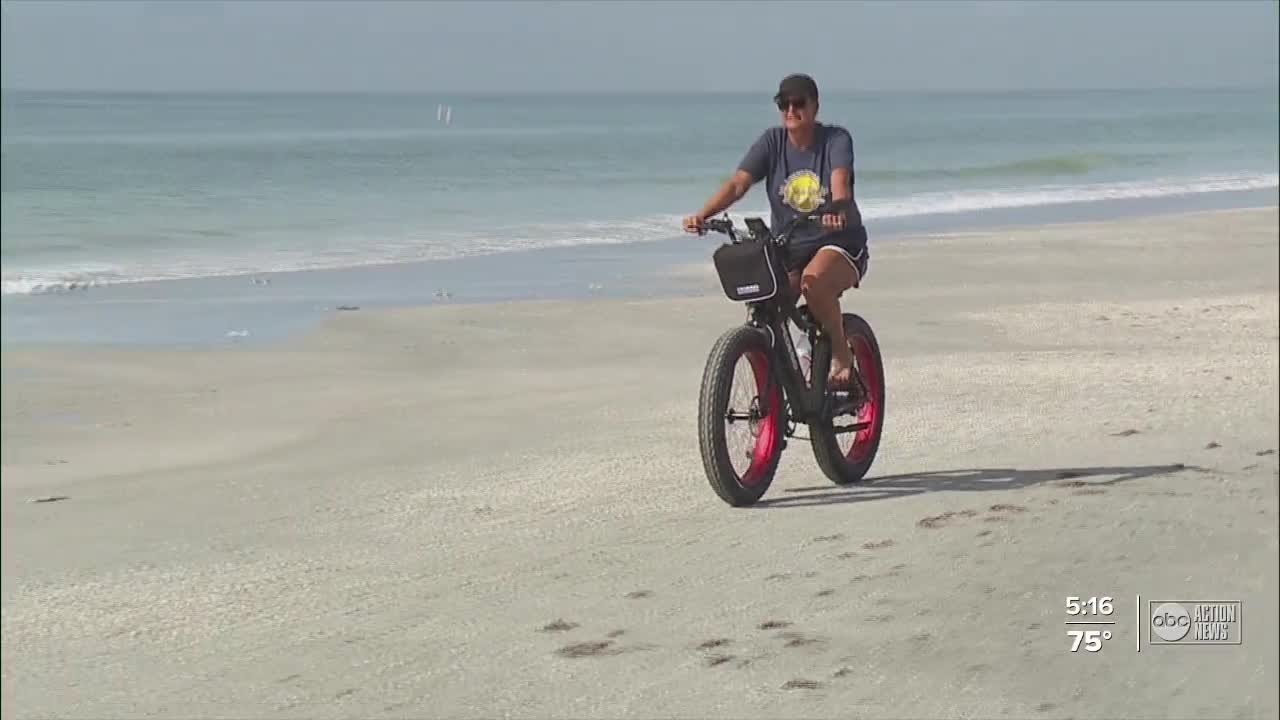 person riding electric bike by the beach