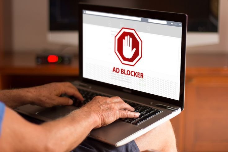 person using laptop with adblock extension installed