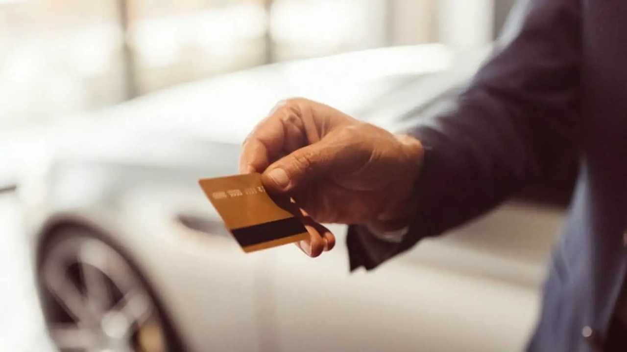 persona comprando neumaticos con tarjeta de credito