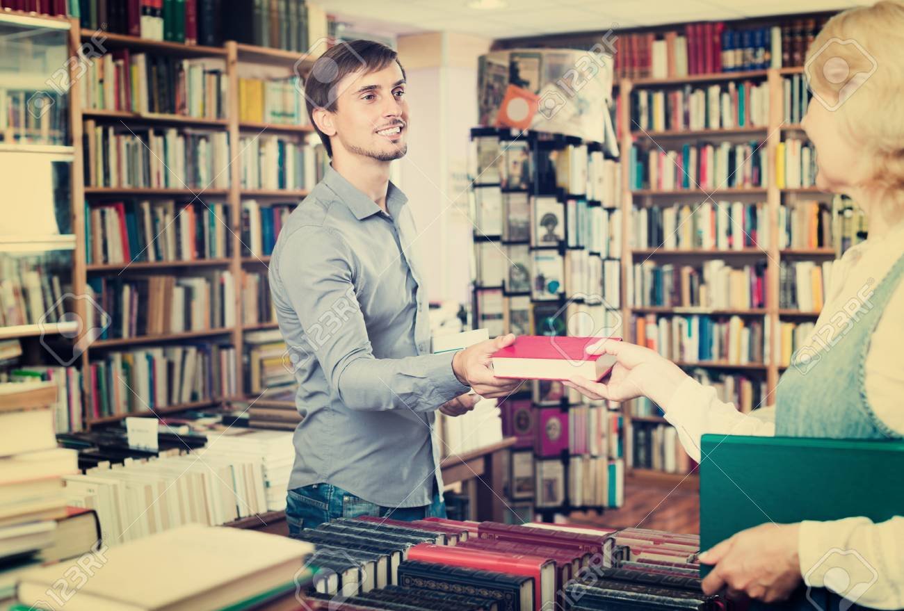 persona entregando libros en tienda de libros