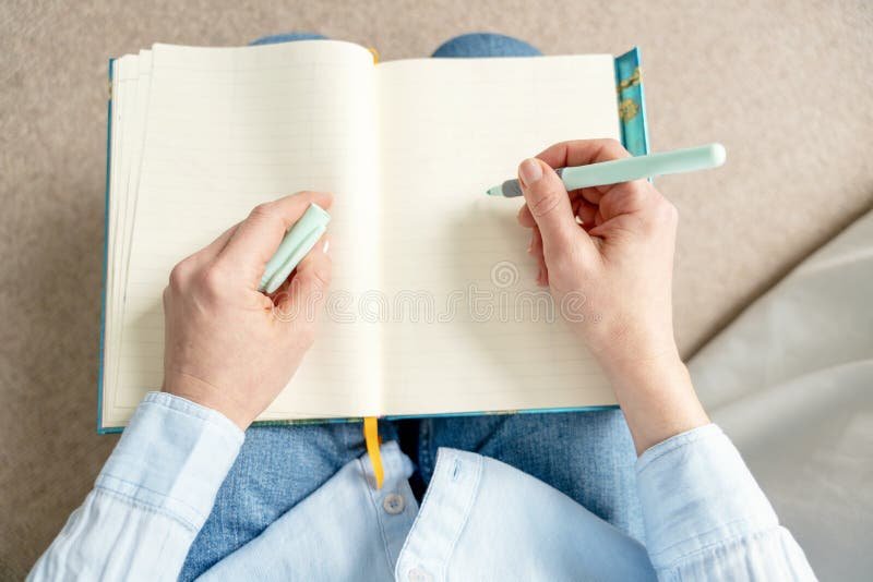persona escribiendo en un libro desde casa