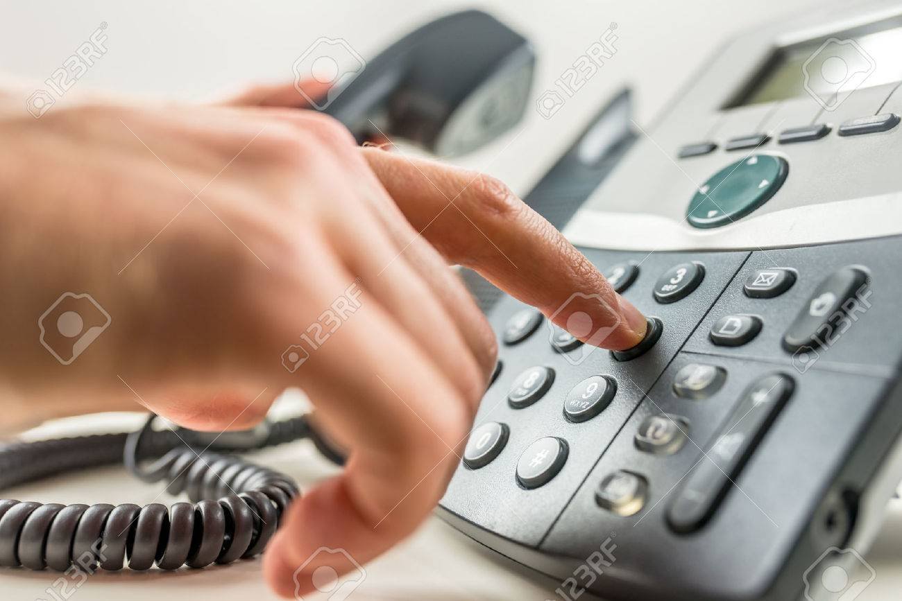 persona marcando un numero en un telefono