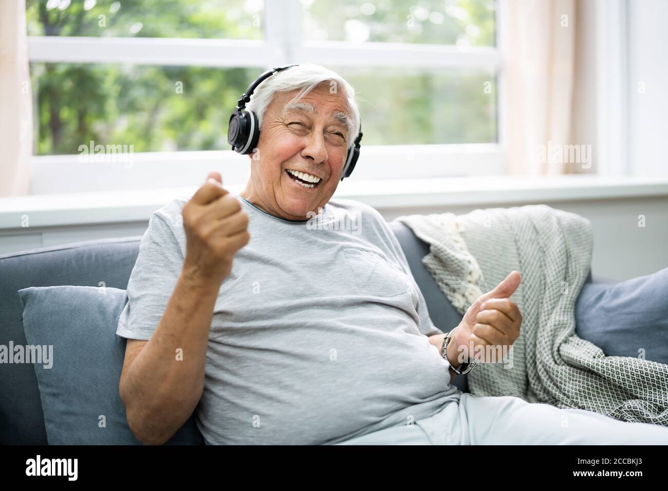 persona mayor sonriendo usando audifonos modernos