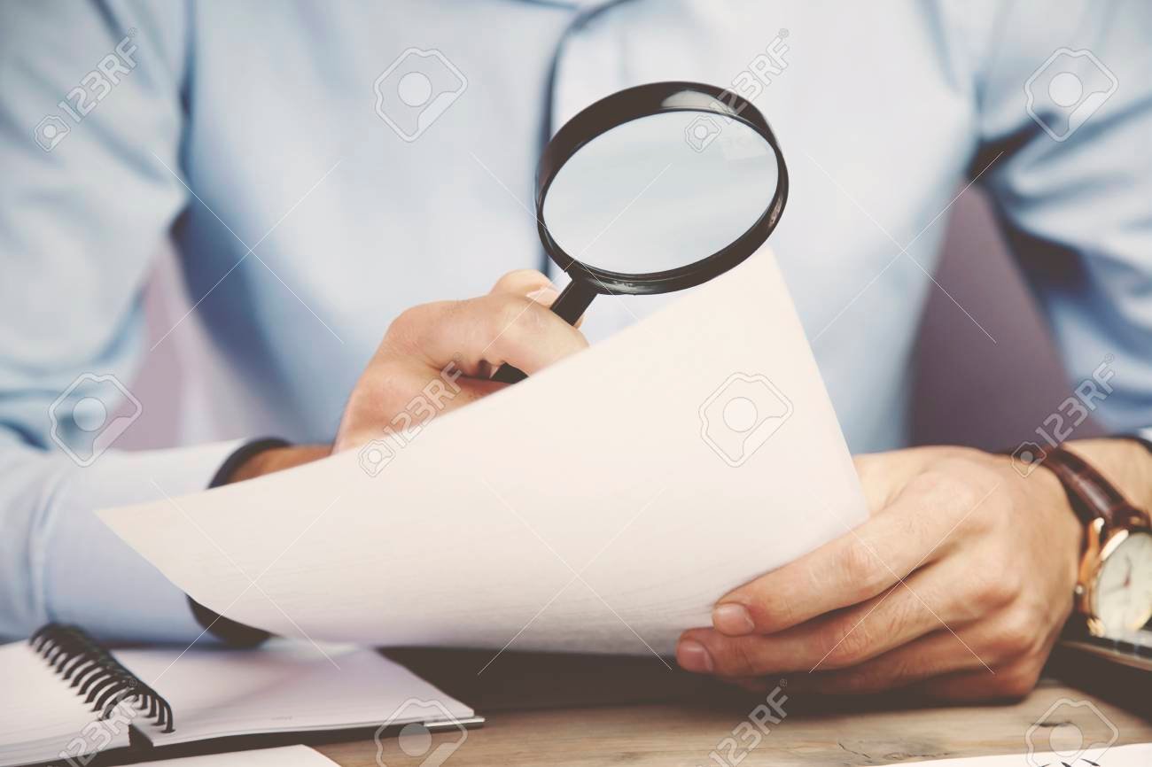 persona revisando contrato con lupa