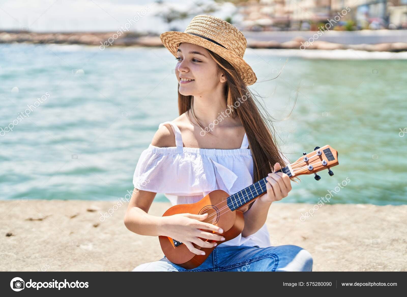 persona tocando el ukelele en la playa