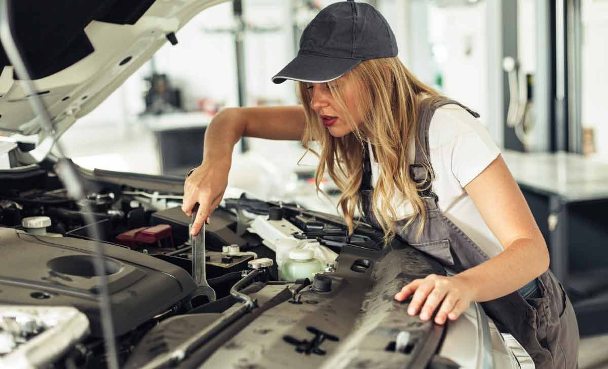 tecnico automotriz inspeccionando un motor de coche
